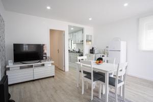 a kitchen and dining room with a white table and chairs at Casa Fonte Nova in Nazaré