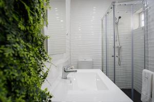 a bathroom with a sink and a glass shower at Casa Fonte Nova in Nazaré +23 photos