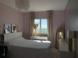 ein Schlafzimmer mit einem weißen Bett und einem Fenster in der Unterkunft Villa piscine avec vue exceptionnelle in Puéchoursi
