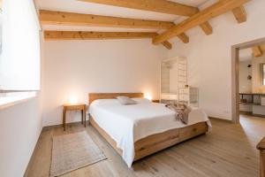 1 dormitorio con 1 cama blanca grande y suelo de madera en ADQ Abbraccio della quercia, en Buje