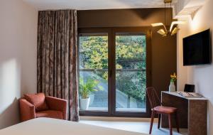 a room with a window and a chair and a desk at Axel Hotel San Sebastián - Adults Only in Donostia-San Sebastián