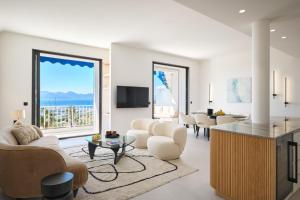 Les DUNES 3 BEDS CROISETTE BEACHES Sea VIEW في كان: غرفة معيشة بأثاث أبيض ونافذة كبيرة