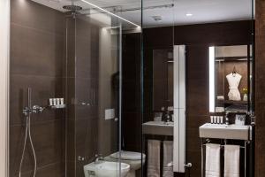 a bathroom with a shower and a toilet and a sink at Axel Hotel San Sebastián - Adults Only in Donostia-San Sebastián