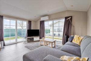 a living room with a couch and a tv at Zeeparken Haerendycke, Seacottage 4223 in Wenduine