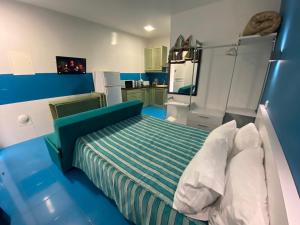 a blue bedroom with a bed and a kitchen at Estúdio Berlenga in Nazaré