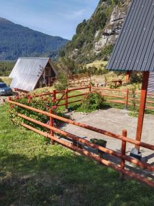 una recinzione di legno di fronte a un campo con una casa di CABAÑA PARCELA VISTA HERMOSA a Puerto Aisén