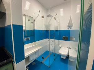 baño azul y blanco con 2 aseos y lavamanos en Estúdio Berlenga, en Nazaré