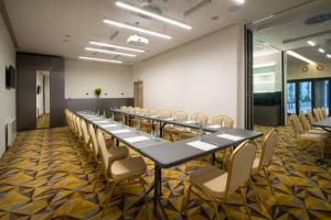 een lange vergaderzaal met een lange tafel en stoelen bij Hotel Essence in Praag