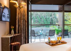 a bedroom with a bed and a view of a patio at Axel Hotel San Sebastián - Adults Only in Donostia-San Sebastián