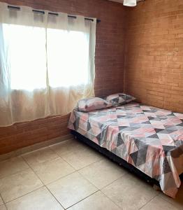 1 dormitorio con cama y pared de ladrillo en GV Apartamentos-2qt 1banh área central - ar cond en Governador Valadares