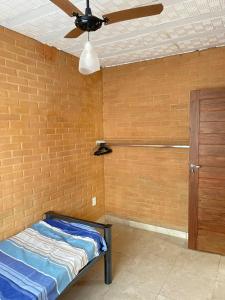 Habitación con cama y ventilador de techo. en GV Apartamentos-2qt 1banh área central - ar cond, en Governador Valadares
