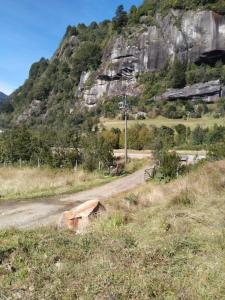 uma estrada de terra em frente a uma montanha em CABAÑA PARCELA VISTA HERMOSA em Puerto Aisén