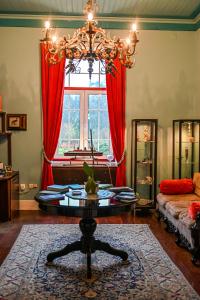 a living room with a chandelier and a table at Vintage Balcony Guesthouse in Ovar