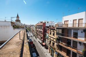 Blick auf eine Stadtstraße mit Gebäuden und einem Zug in der Unterkunft Elegante y céntrico apartamento in Sevilla