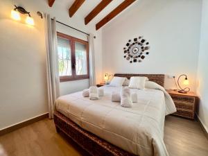 a bedroom with a bed with white sheets and a window at Casa Laura by Sun & Sea Homes in Moraira