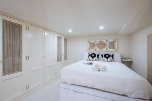 ein Schlafzimmer mit einem weißen Bett mit zwei darauf liegenden Hunden in der Unterkunft Elegante y céntrico apartamento in Sevilla
