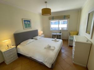 um quarto com uma cama branca e uma janela em Palm Garden em Vilamoura