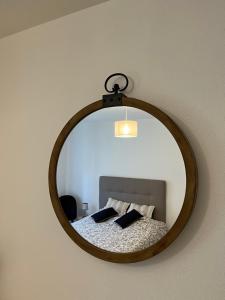 uno specchio appeso a una parete con un letto di Le gîte de Marc - Parking privé gratuit + terrasse a Colmar