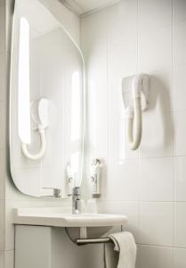 La salle de bains est pourvue d'un lavabo et d'un miroir. dans l'établissement ibis Toulouse Pont Jumeaux, à Toulouse