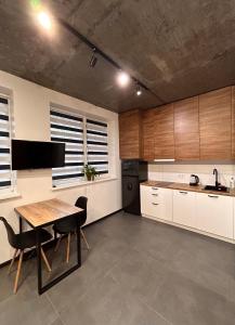 a kitchen with wooden cabinets and a table and chairs at Loft на Кониського, центр in Dnipro