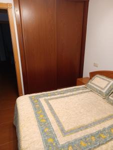 Casa s.pedro visma في لا كورونيا: سرير عليه لحاف في غرفة النوم