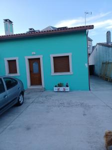 una casa azul con un coche aparcado delante de ella en Casa s.pedro visma, en A Coruña