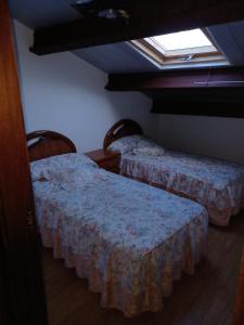 two beds in a room with a window at Casa s.pedro visma in A Coruña
