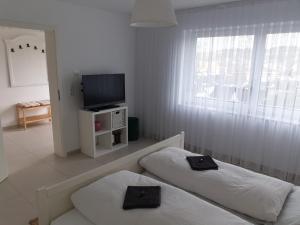 1 dormitorio con 2 camas, TV y ventana en Schöne Wohnung über Wissen, en Wissen