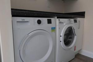 uma máquina de lavar e secar roupa num quarto em 7 Swiftsure - 4 Bedroom Luxury and Spacious Home em Milton Keynes