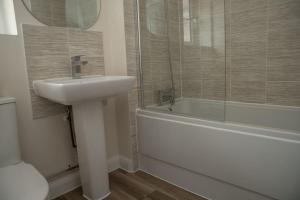 uma casa de banho com um lavatório, um chuveiro e um WC. em 7 Swiftsure - 4 Bedroom Luxury and Spacious Home em Milton Keynes