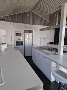 诺加罗LES CERISIERS 2的厨房配有白色橱柜和白色冰箱。