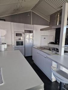 a kitchen with white cabinets and a white refrigerator at LES CERISIERS 2 Chambre 2 in Nogaro