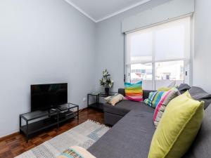 a living room with a couch and a tv at Akisol Faro Sunny in Faro