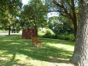 a park bench sitting in the grass next to a tree at Fewo im Alten Land in Hamburg