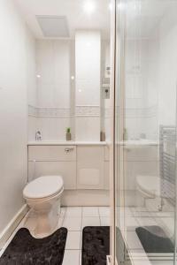 een witte badkamer met een toilet en een douche bij Stunning Flat by Quayside with Balcony!! in Newcastle upon Tyne