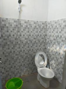 Mandeh Guesthouse Padang في بادانج: حمام به مرحاض ودلو أخضر