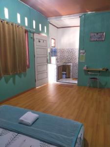 Mandeh Guesthouse Padang في بادانج: غرفة بسرير وغرفة مع طاولة