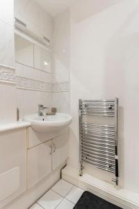a white bathroom with a sink and a mirror at Stunning Flat by Quayside with Balcony!! in Newcastle upon Tyne