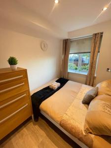 a bedroom with a bed and a dresser and a window at Stunning Flat by Quayside with Balcony!! in Newcastle upon Tyne