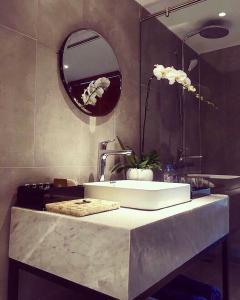 ein Bad mit einem Waschbecken und einem Spiegel in der Unterkunft Apartment in Arena Cam Ranh near the airport in Cam Ranh
