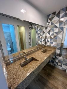 a bathroom with two sinks and a large mirror at Bahia Pelô Hostel in Salvador