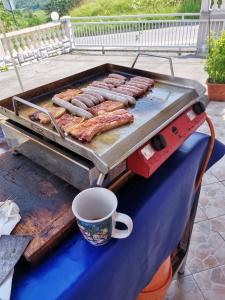 a grill with a bunch of sausages on it at Panorama Apartman in Molvice