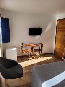 a room with a table and two chairs and a television at Bahia Pelô Hostel in Salvador