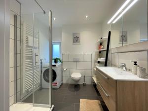 Un baño con lavabo y lavadora. en Bunter Hund Apartments - Zentrales Apartment, Parkplatz, Wintergarten, Kinderzimmer, en Rothenburg ob der Tauber