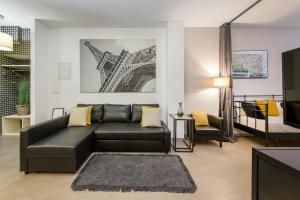 a living room with a black leather couch and a tv at Apartment Napoleon in Ljubljana