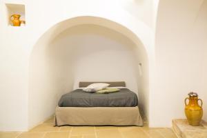 1 dormitorio con 1 cama en una habitación blanca en Il Trullo del viaggiatore, en Alberobello