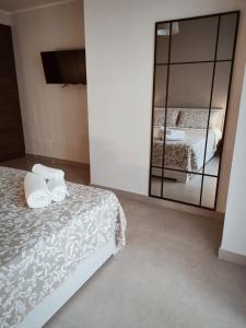 1 dormitorio con cama y espejo grande en Camera sul Mare en Messina