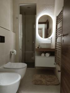 a bathroom with a toilet and a sink and a mirror at Camera sul Mare in Messina