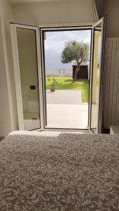 a bedroom with a large sliding glass door to a yard at Camera sul Mare in Messina