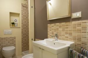 uma casa de banho com um lavatório, um WC e um espelho. em Iolanda Apartment 30m from Seaside em Alghero